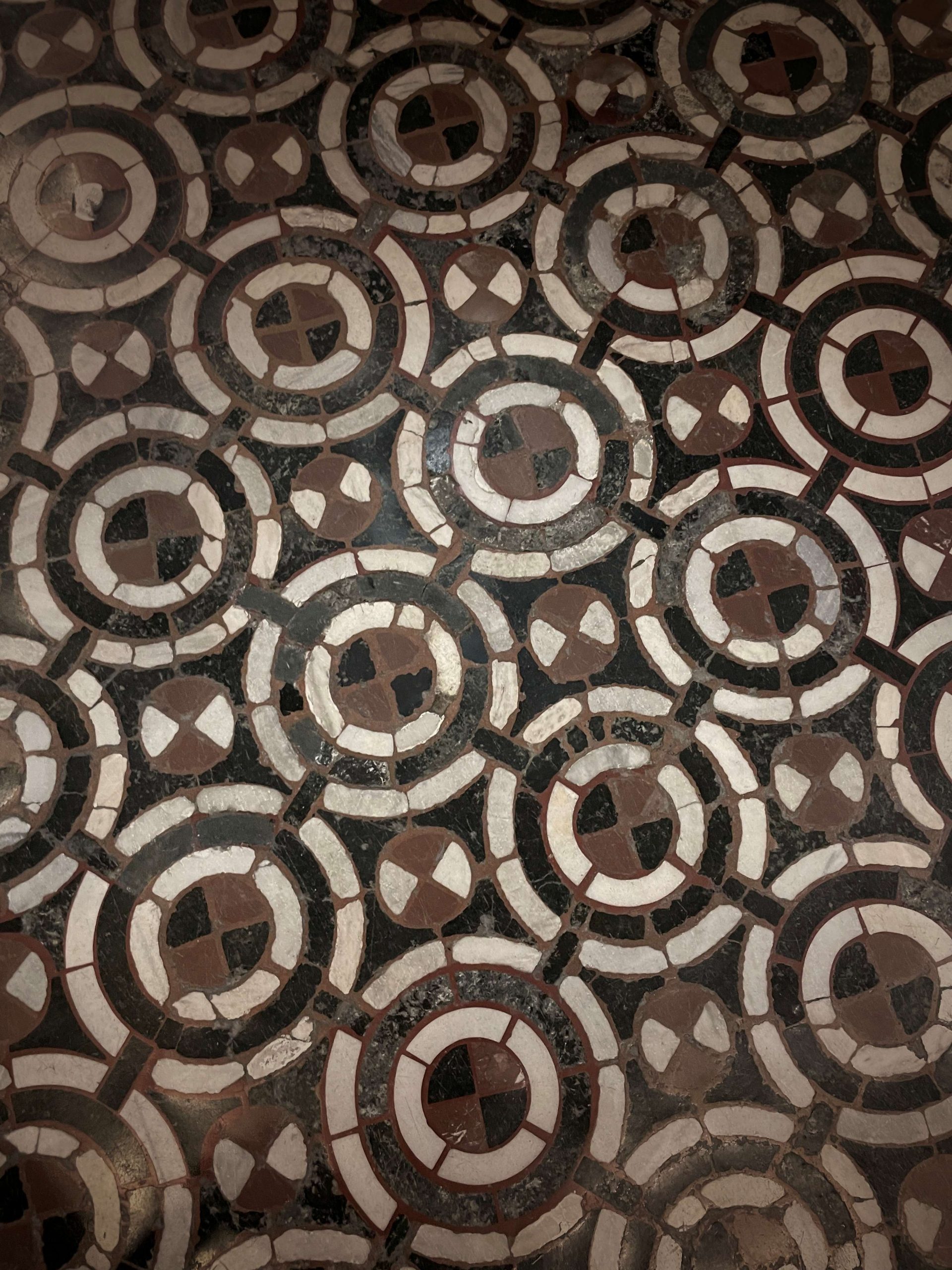 Italian stone flooring in shades of terracotta, black, and cream