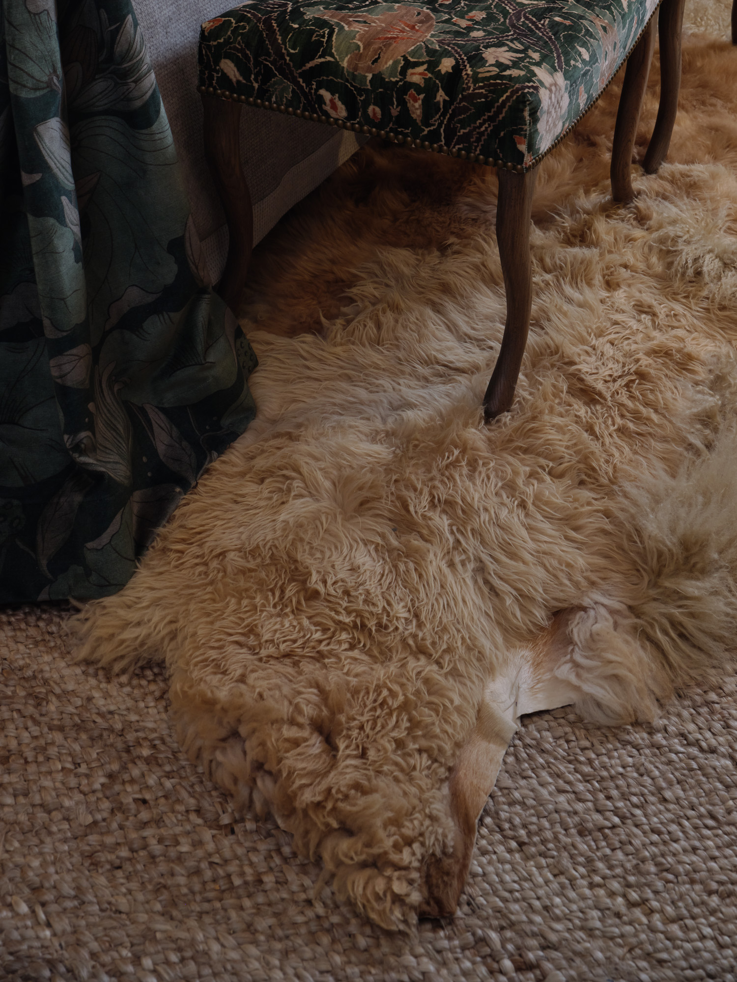 Layered sheepskin rug over jute area rug
