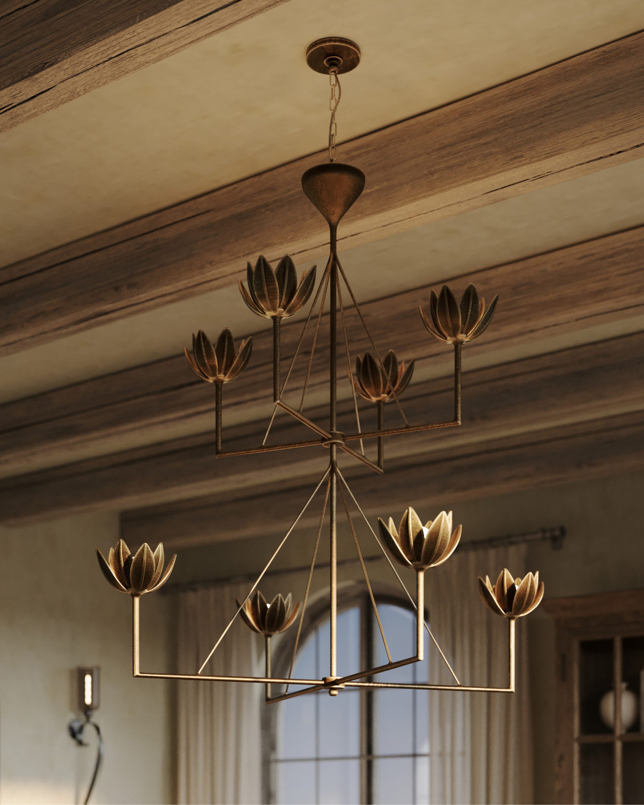 An antique bronze leaf two-tier chandelier hangs from a dining room ceiling with wood beams