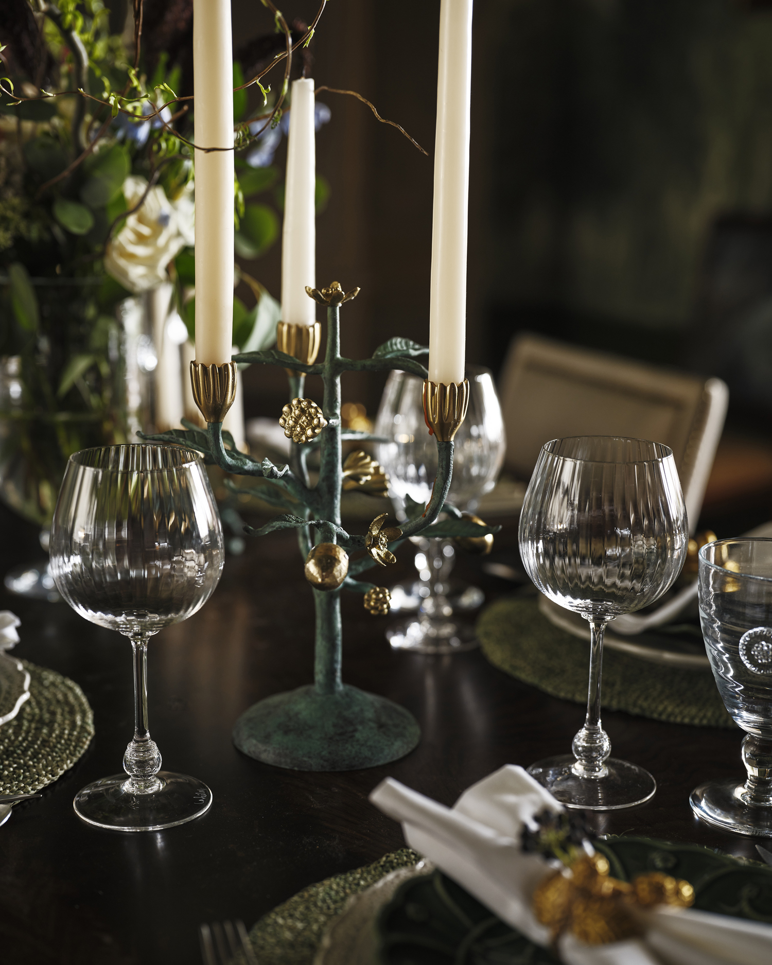 a dining table set with candelabras and juliska wine glasses and dinnerware